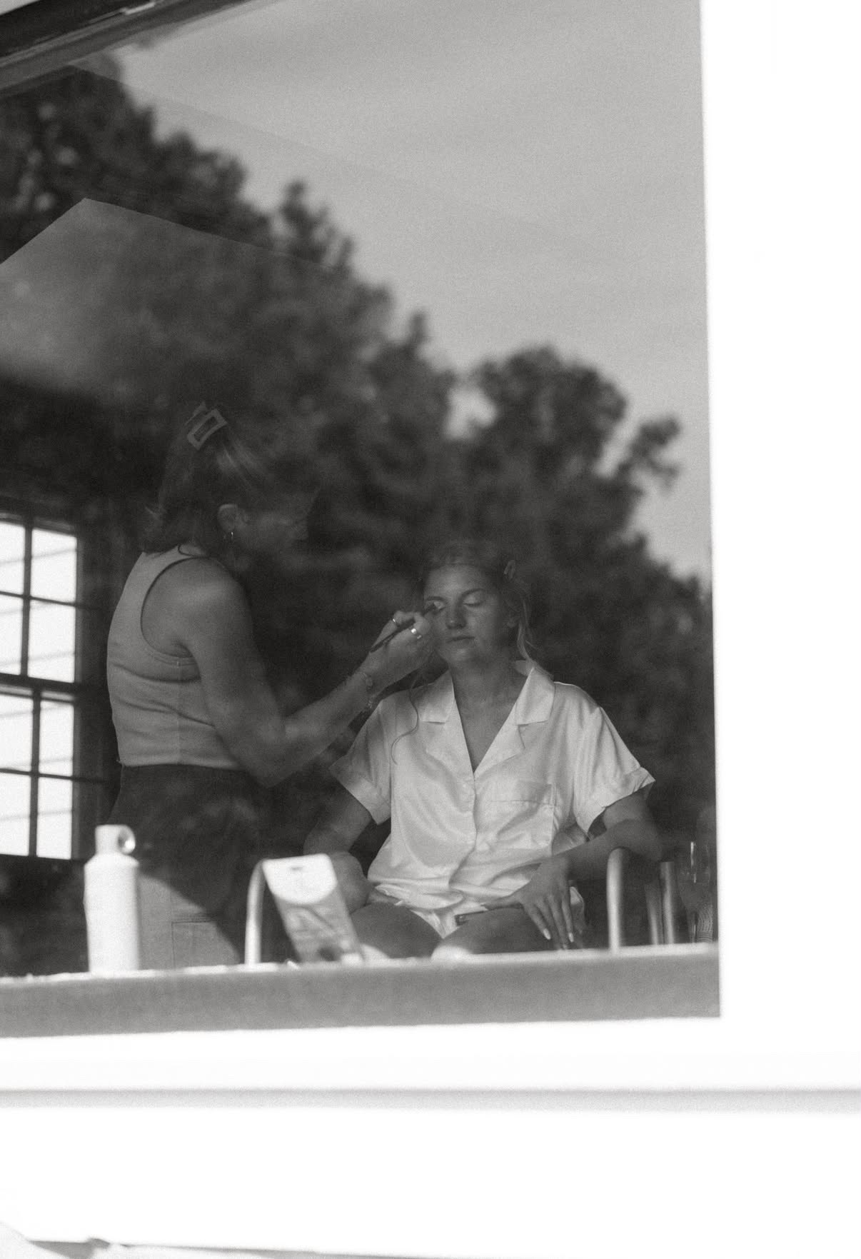 Megan applying a bride’s makeup while getting ready